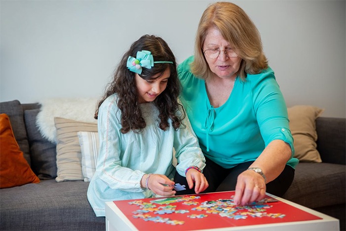 puzzle pieces, a child and a woman playing puzzle, puzzle putting together, puzzle