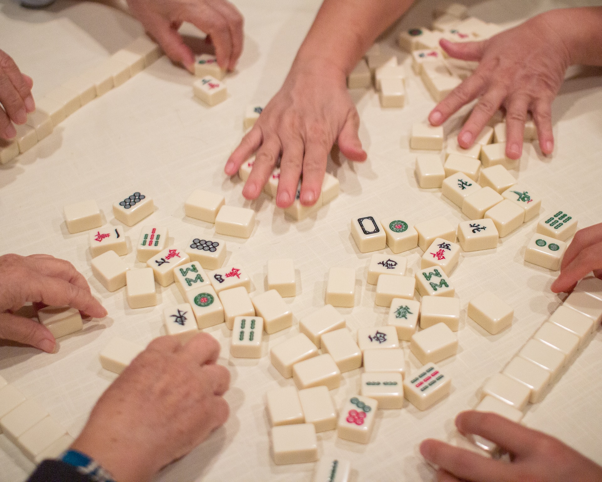 Person playing white and brown mahjong blocks
