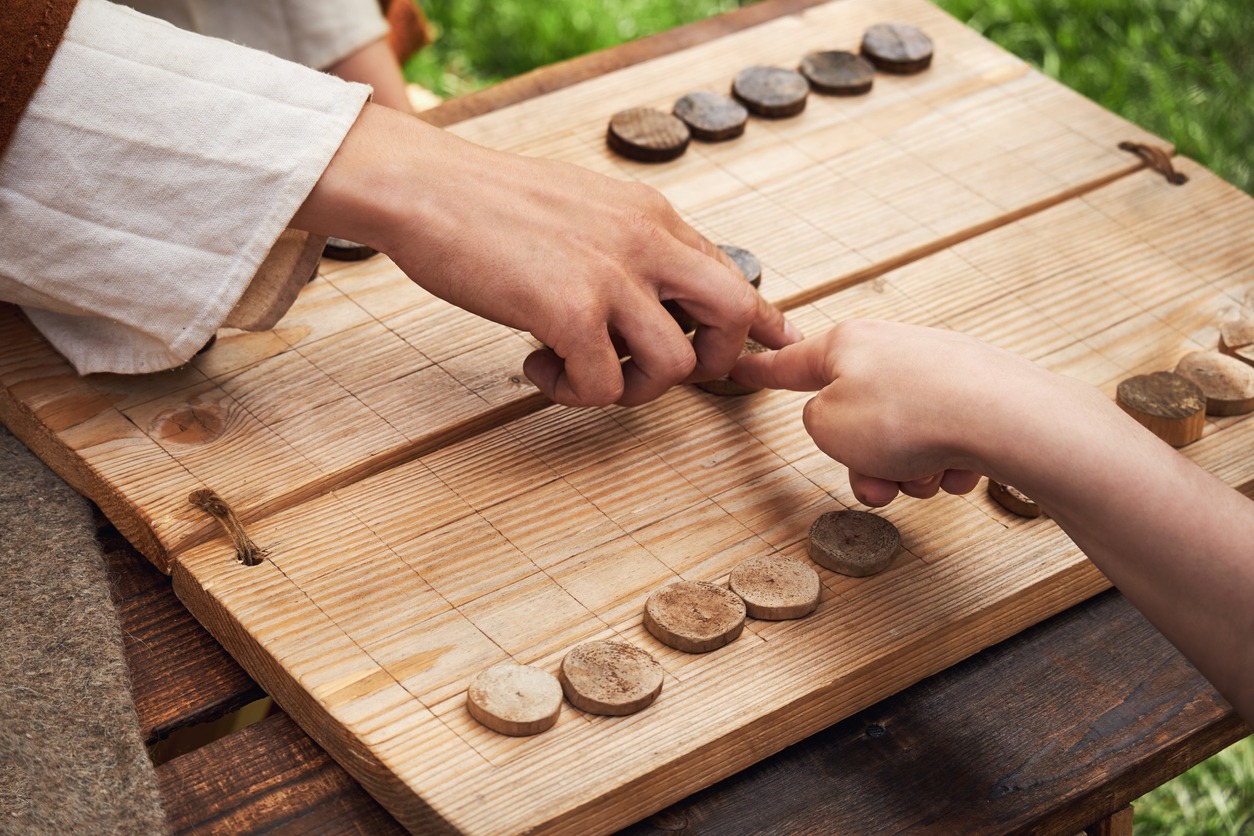 A man playing a game of checkers with another man photo