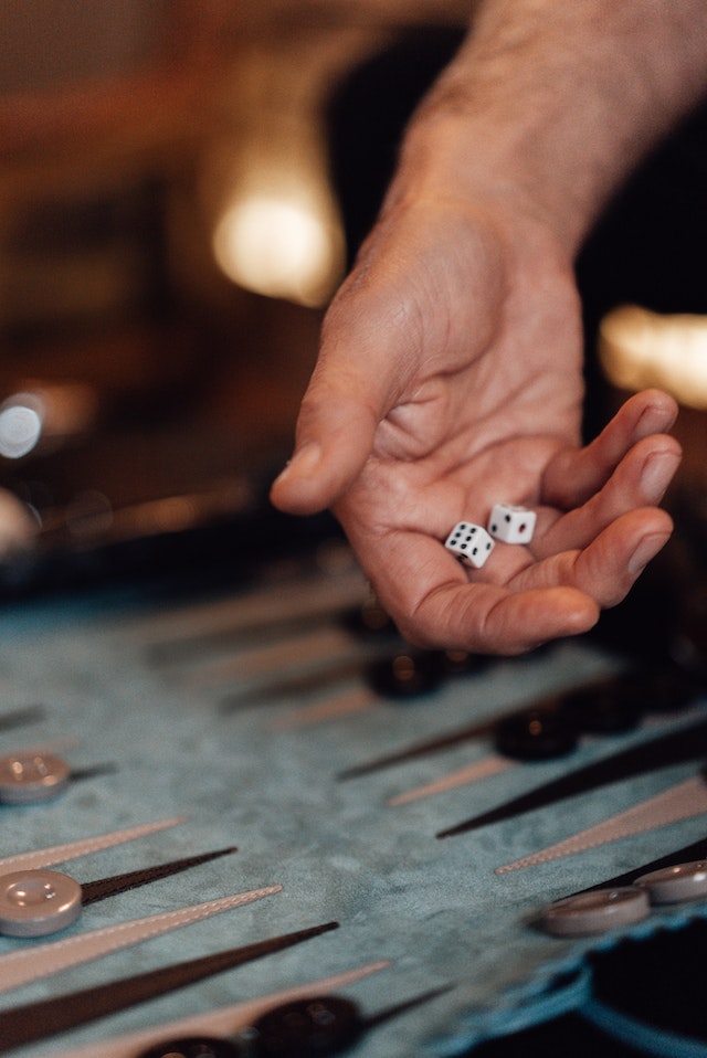 A man throwing a dice on the board