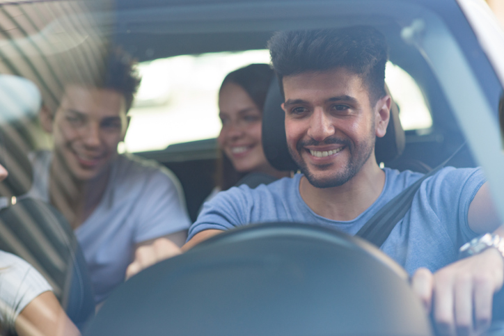 three teenagers talking and laughing in the car