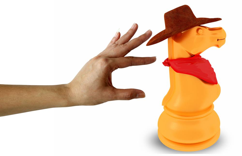 A huge knight chess piece with cowboy hat and scarf