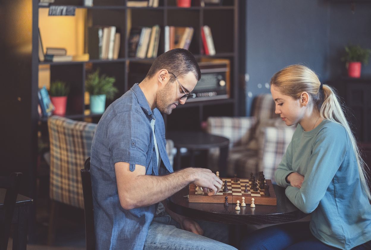a couple playing chess inside a café