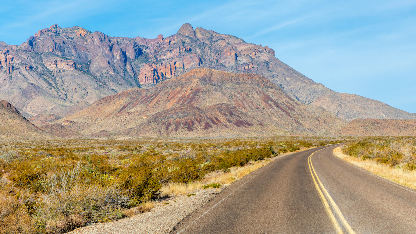 Road through the Chihuahuan Desert with tall mountains in the background