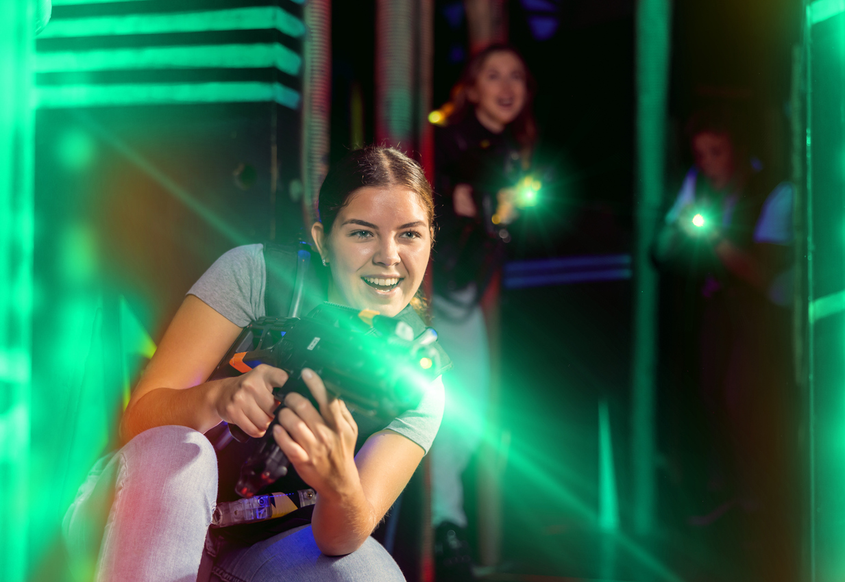 Girl running and dodging while playing lasertag
