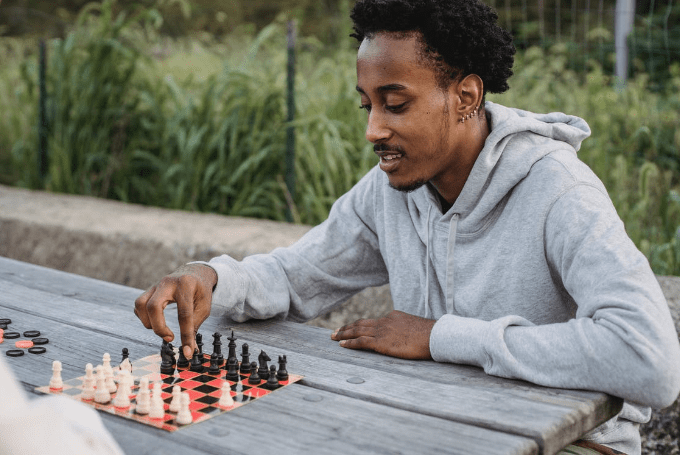 focused-black-man-making-chess-move