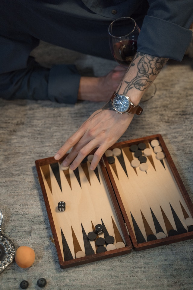 A man playing Backgammon on the floor