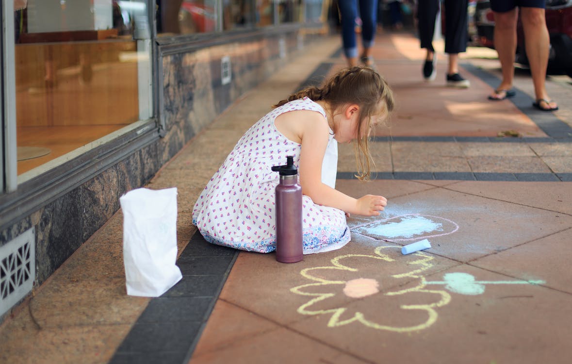 A Girl Drawing on the ground using a chalk