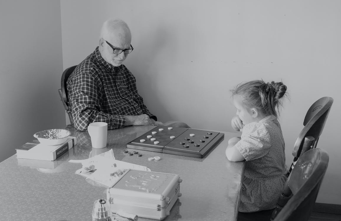 Man And Little Girl Playing Checkers